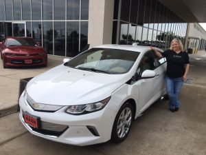 Nerissa by her 2017 Chevy Volt and wearing an "It's All Good" T-shirt