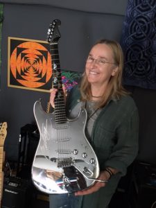 Melissa showing a "Mustang" guitar given to her by the Ford Institute